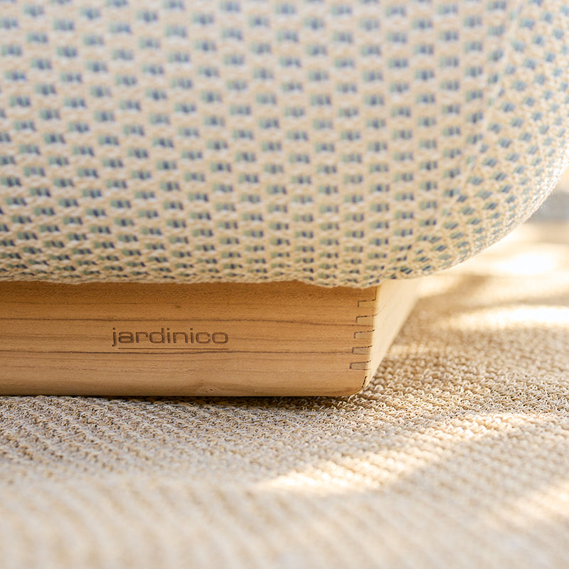 Close-up view of a woven Jardinico outdoor furnishing with a wooden frame, showcasing the brand's signature design and quality craftsmanship for outdoor spaces.