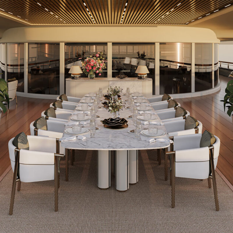 Elegant dining room with oval marble table, plush white chairs, and scenic view through floor-to-ceiling windows.