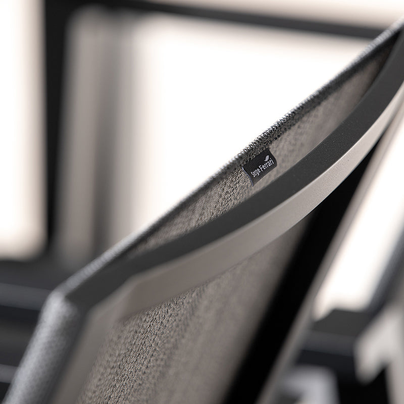 Close-up view of a black and gray mesh backrest on a modern chair, highlighting the fabric texture and the "Supatrak" label.